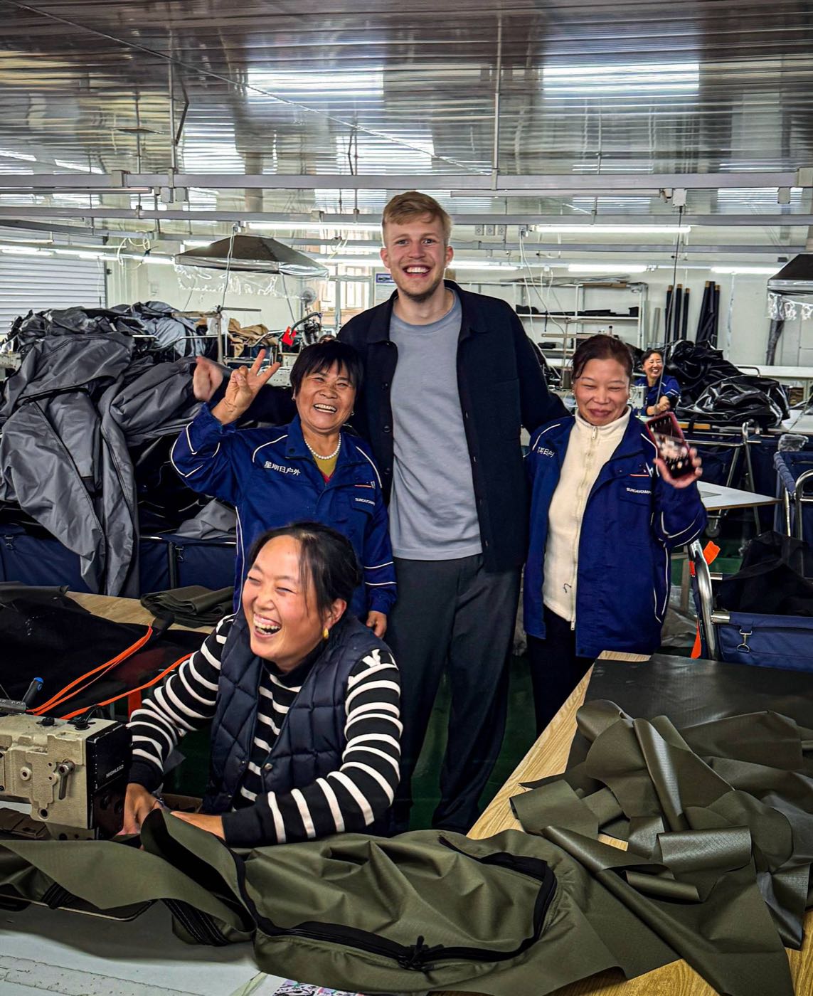 Lukas Selbach mit Näherinnen in einer Produktionshalle in China